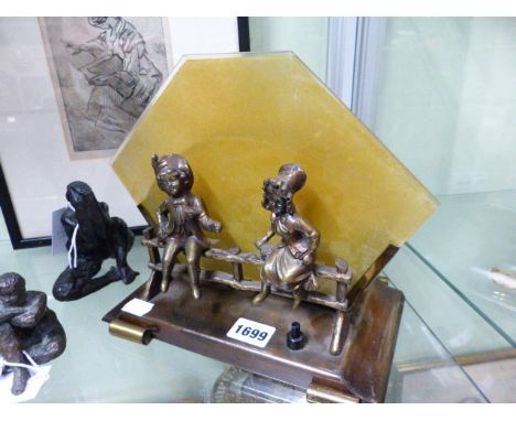 A VINTAGE NOVELTY DESK LAMP IN THE ART DECO STYLE, GLASS PANEL SHADE MOUNTED WITH FIGURE OF CHILDREN SEATED ON A GATE