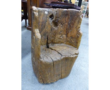 AN EARLY CARVED RUSTIC TRUNK FORM SEAT OF DUG OUT FORM.   W.56 x H.67cms.