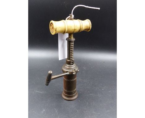 A VICTORIAN BONE HANDLED BRASS TAP ACTION CORKSCREW.