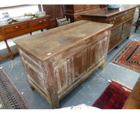 AN EARLY 18th.C.OAK COFFER WITH PLANK TOP OVER FOUR RAISED PANEL FRONT ON STILE SUPPORTS AND OLD BUT LATER LIME WASH FINISH. 