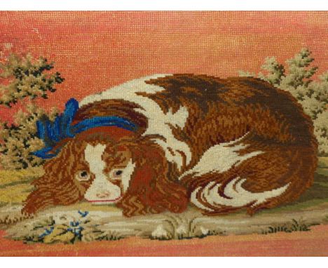 A BERLIN WOOLWORK PICTURE OF A RECLINING KING CHARLES SPANIEL WEARING A BLUE SASH COLLAR WITHIN GILT FRAME.   41.5 x 58cms.