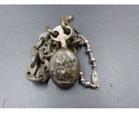 AN ANTIQUE VULCANITE MOURNING LOCKET AND CHAIN CONTAINING A PORTRAIT OF A LADY IN 19th C. DRESS. 