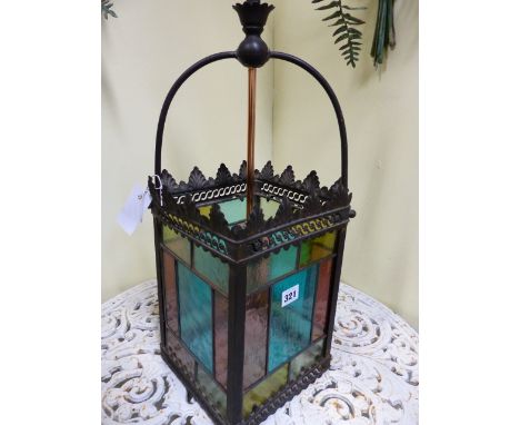 AN ANTIQUE BRASS FRAMED HALL LANTERN WITH LEADED STAINED GLASS PANELS.   H.64cms.