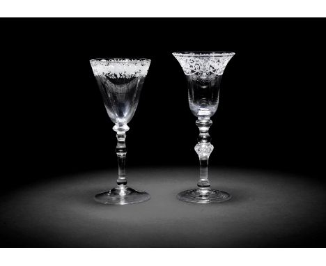 Two engraved light baluster wine glasses, circa 1750One with a bell bowl, the rim with a formal floral, foliate scrollwork an