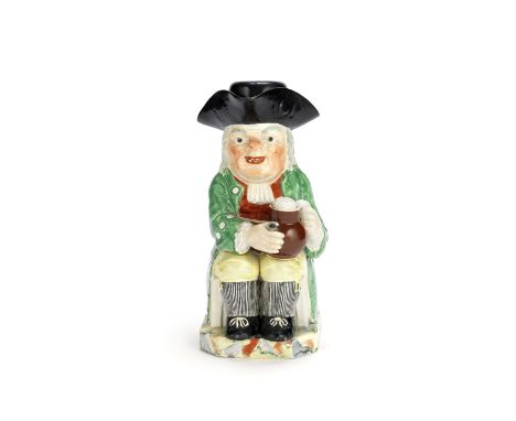 An enamelled creamware Toby Jug and cover, circa 1790Attributed to Neale &amp; Co, of traditional form, seated and holding a 