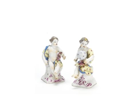 A rare pair of Bow figures of putti, circa 1758-60Emblematic of Music and Astronomy, seated on square bases painted with puce