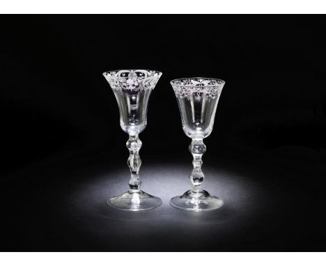 Two engraved light baluster wine glasses, circa 1760The rims with formal floral and foliate scrollwork borders, one with a be