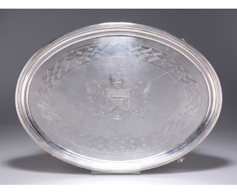 A GEORGE III SILVER SALVER by William Bennett, London 1802, oval, with a reeded border, engraved with an armorial, on four br