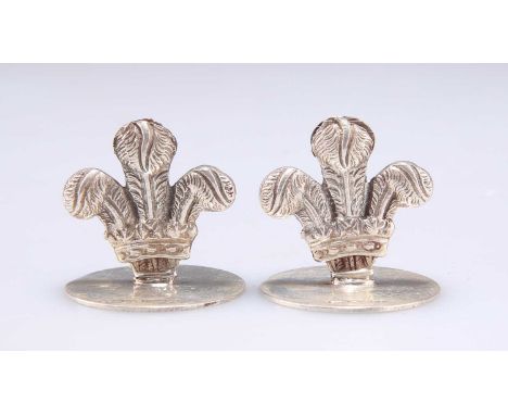 A PAIR OF ELIZABETH II SILVER MENU HOLDERS by E &amp; J, London 2017, cast as Prince of Wales feathers, on plain circular bas