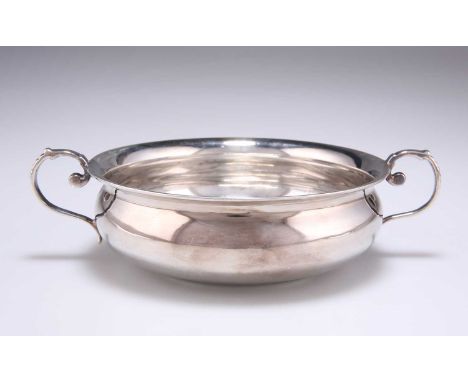 A LATE VICTORIAN SILVER SHALLOW TWO-HANDLED BOWL by Josiah Williams &amp; Co, London 1896, of squat form with scroll handles.