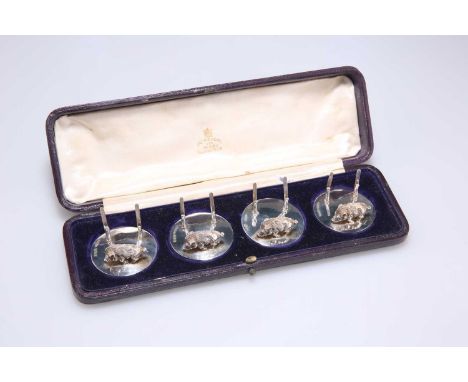 A SET OF FOUR EDWARDIAN SILVER MENU HOLDERS by Stuart Clifford &amp; Co, London 1909, each cast with a walking warthog on a c