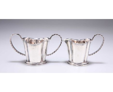 A GEORGE V SILVER TWO-HANDLED SUGAR BOWL AND CREAM JUG by W T Hickman, Birmingham 1945, of quatrefoil form with large loop ha