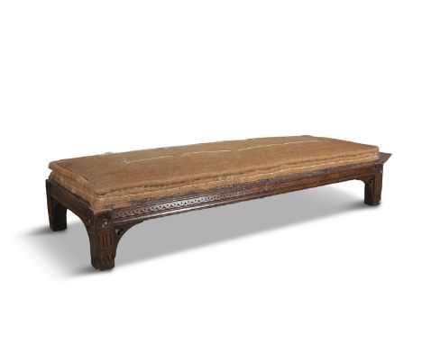 A VICTORIAN CARVED OAK OBLONG STOOL, in the Gothic taste, the sides decorated with a row of lappets on squared legs headed by