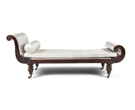 A REGENCY MAHOGANY FRAMED DAYBED, with twin scroll ends upholstered in pale silk with stippled design, on fluted tapering leg