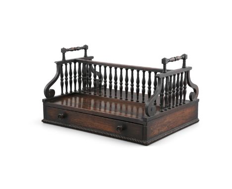AN IRISH WILLIAM IV ROSEWOOD DESK BOOK TROUGH, with raised side handles and spindle turned central division, on rectangular s