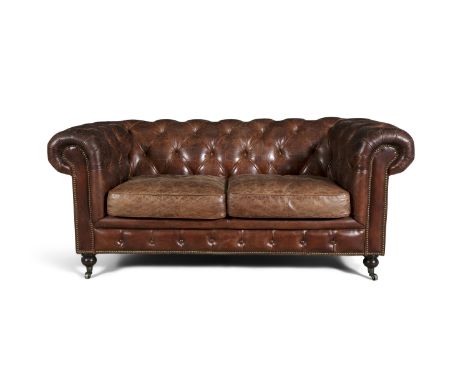 A VICTORIAN STYLE BROWN LEATHER CHESTERFIELD SETTEE, covered with button back upholstery and fitted with two loose cushions, 