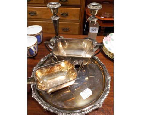 A pair of plated candlesticks, sugar bowl and cream jug, salver and pickle fork 