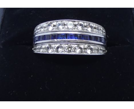 Early 20th century day and night ring, one side set with channel set calibre cut rubies, the other side sapphires, with hinge