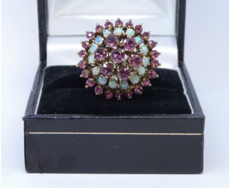 Large opal and ruby cluster ring, in a circular target design, on yellow gold shank stamped 14k, ring size M