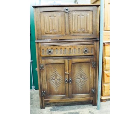 A reproduction oak cocktail cabinet with linen fold panel doors drawer and cupboard under 2'6 wide 