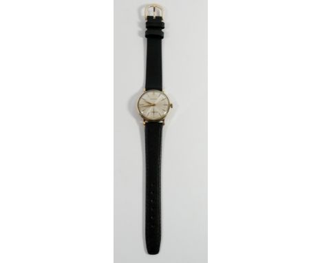 Gents Garrard 9ct gold wristwatch, on black leather strap, with mechanical movement.