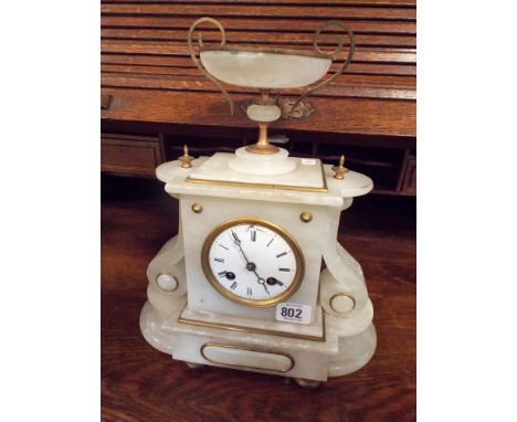 A French striking mantle clock in white onyx case with a bowl shaped top 