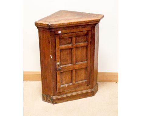 A late Victorian oak wall hanging corner cupboard with fielded panel door 