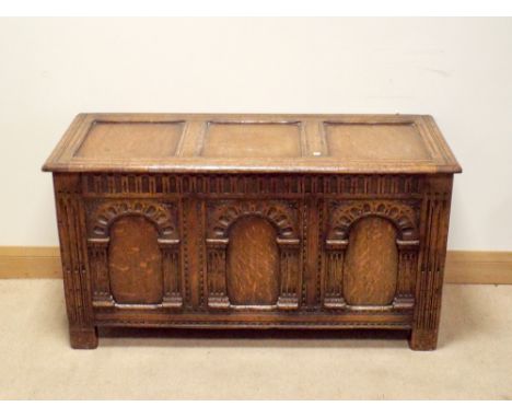 A reproduction oak blanket chest fitted three carved panel front 45" wide 