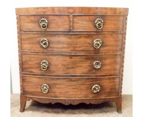 A Georgian mahogany bow front chest of three long and two short drawers with brass ring handles standing on bracket feet, the