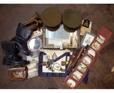 A collection of various military items from the I and II World Wars to include badges, buttons, a bugle, military boots and h