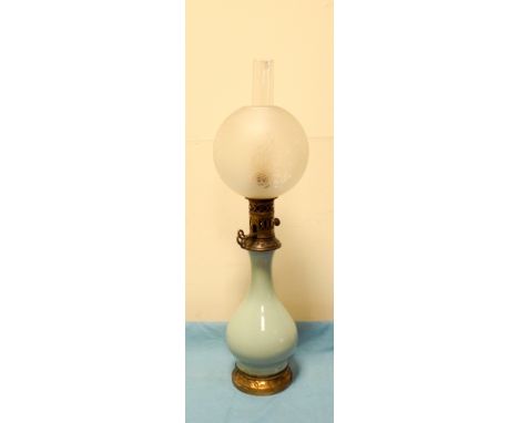A Victorian brass and green china oil lamp with bowl style edge shade      In good condition, the brass base is a little bit 