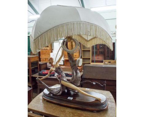 An Art Deco porcelain lady figure table lamp with shade standing on a wooden plinth 