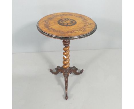 An antique walnut circular top occasional table, with ebonised and inlaid foliate decoration, raised on barley-twist support 