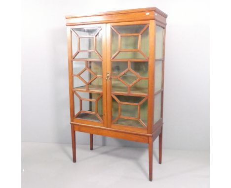 An antique mahogany display cabinet, with two lattice glazed doors and two fixed shelves. 94x160x42cm. Fair condition, the le