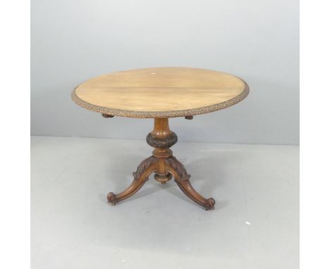 A 19th century Art Nouveau mahogany circular tilt-top occasional table, with carved decoration, central turned column and tri