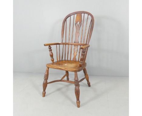 A 19th century elm-seated comb-back Windsor elbow chair with crinoline stretcher.