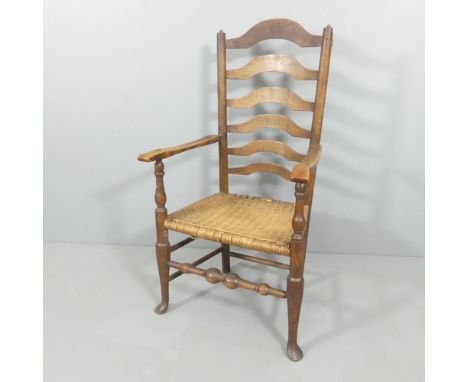 A 19th century ladder back open arm chair in the Lancashire manner, with later rattan seat.