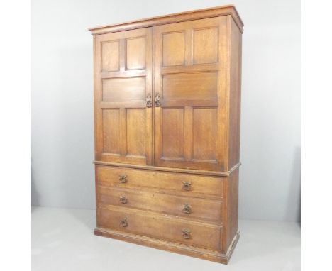 A 19th century oak linen press in three section, the two panelled doors revealing slide fitted and hanging compartments above
