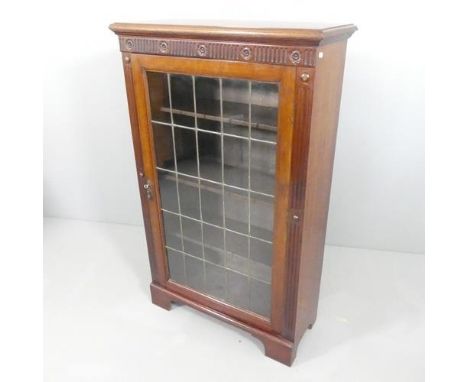 A mahogany bookcase with single leadlight panel door, carved decoration and 3 adjustable shelves.