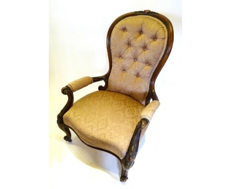 A Victorian Walnut Drawing Room Armchair with a button upholstered back above a stuff-over seat raised upon carved cabriole l