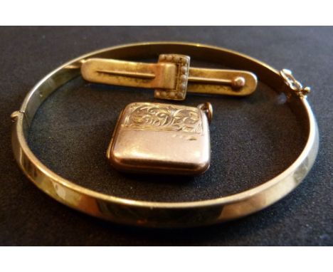 A 9ct gold bangle,10.1 grams together with a bar brooch in the form of a buckle and a gold locket