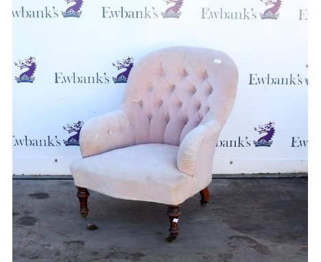 Victorian pink button back fireside armchair, with turned legs and castors