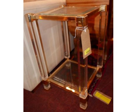 A 1970s French lucite and brass two tiered lamp table with square bevelled glass inserts, H.60cm W.35cm D.35cm 