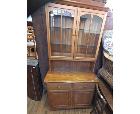 A light oak two drawer, two door sideboard with non-matching bookcase top