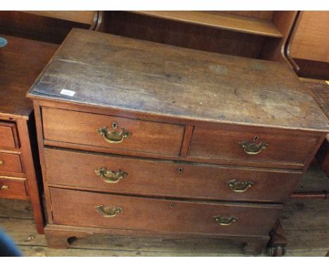 A late Georgian oak chest of two short and two long drawers on bracket feet with brass handles