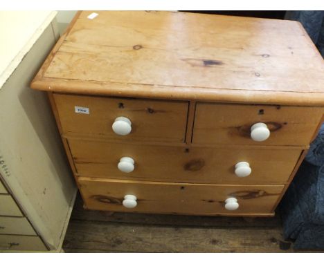 A Victorian stripped chest of two short and two long drawers with ceramic handles and turned feet