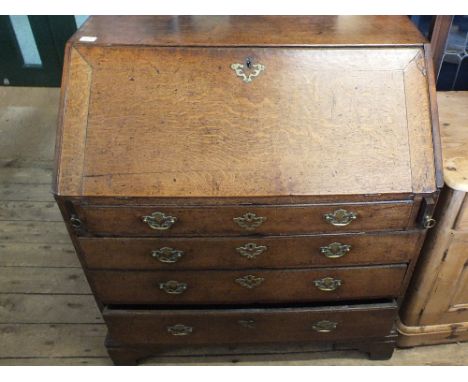 A Georgian oak bureau with fitted interior on bracket feet