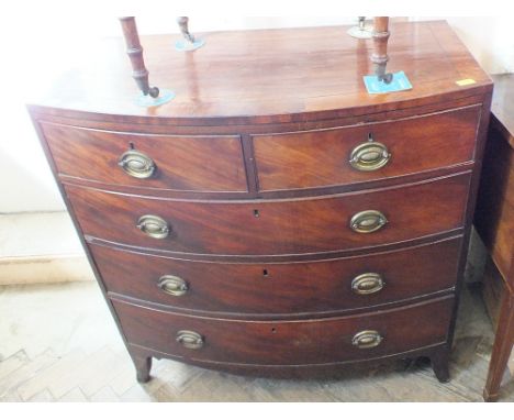 A flame mahogany bow fronted chest of short and three long drawers with metal handles on carved feet