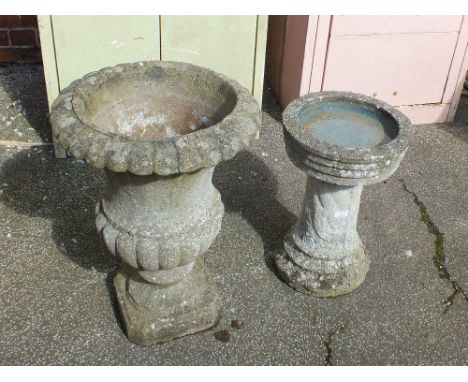 A weathered concrete urn shape planter and a weathered concrete bird bath