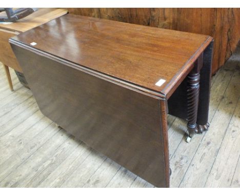 A Victorian mahogany drop leaf table on spiral tapering column legs with ceramic castors